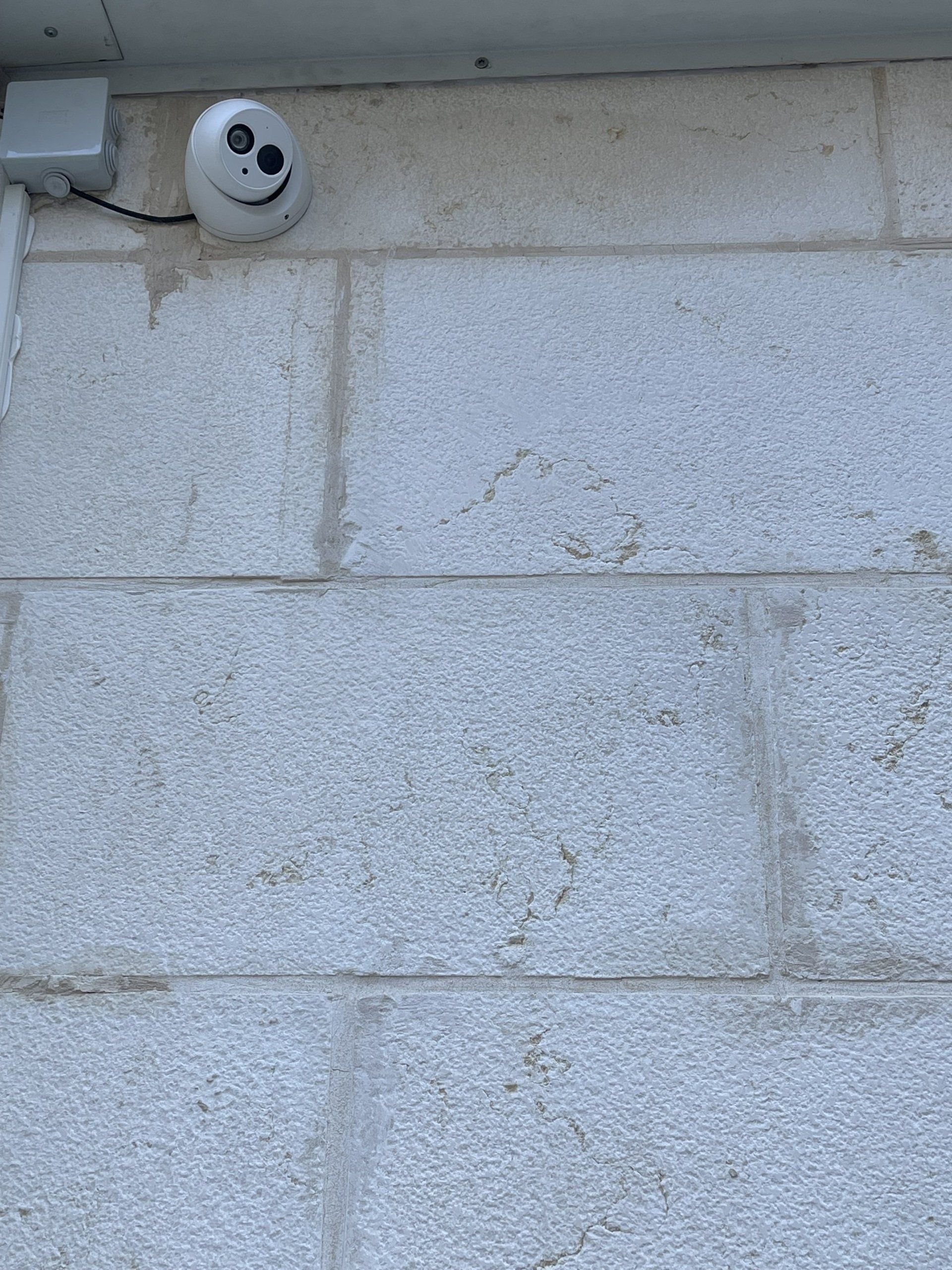 קיר לבנים ועליו פרצוף סמיילי