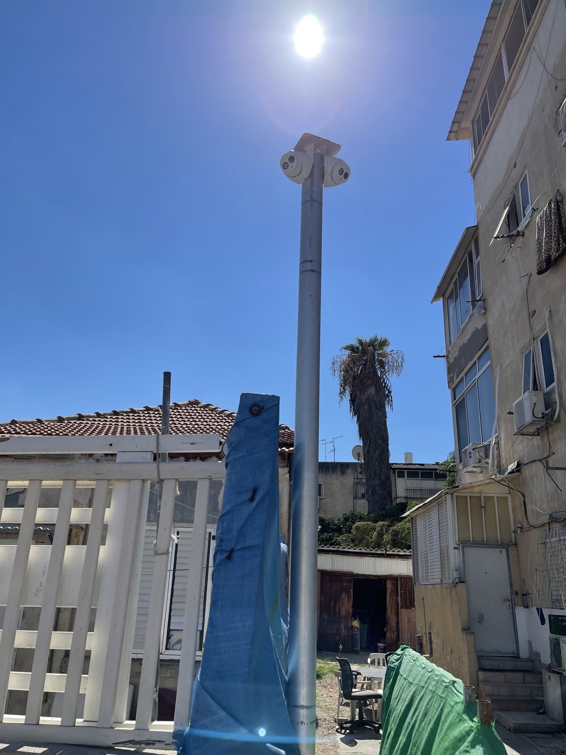 השמש זורחת בבהירות על עמוד מול בניין