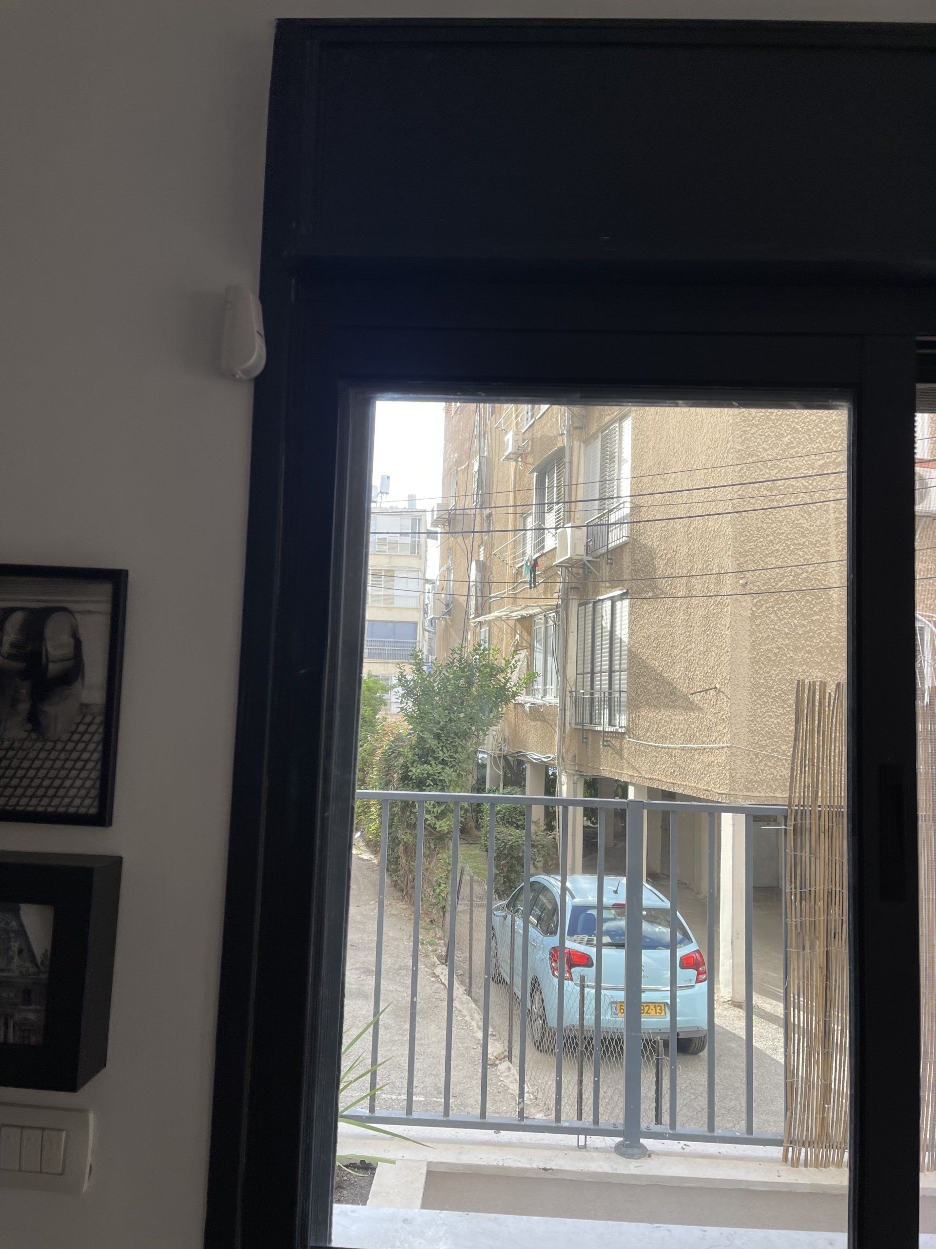 נוף של מכונית חונה מול בניין דרך חלון.