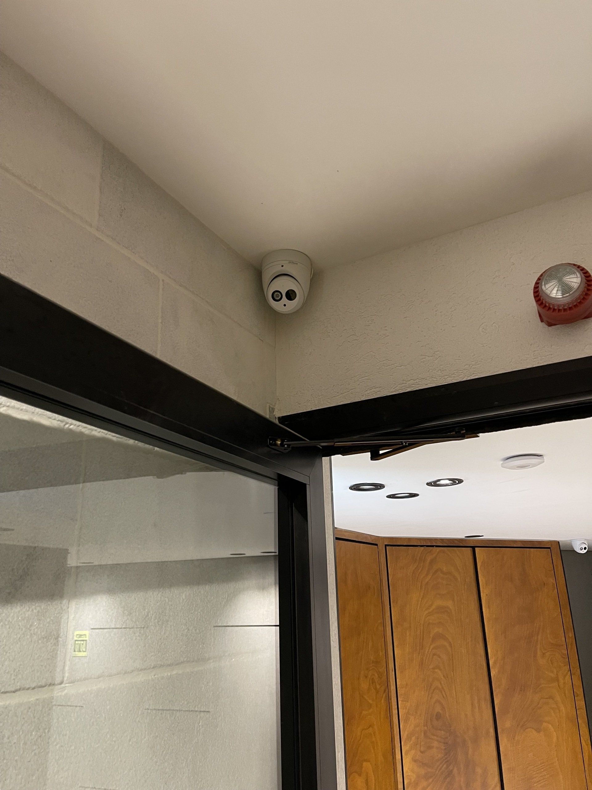 גלאי עשן מותקן על תקרת חדר ליד דלת.