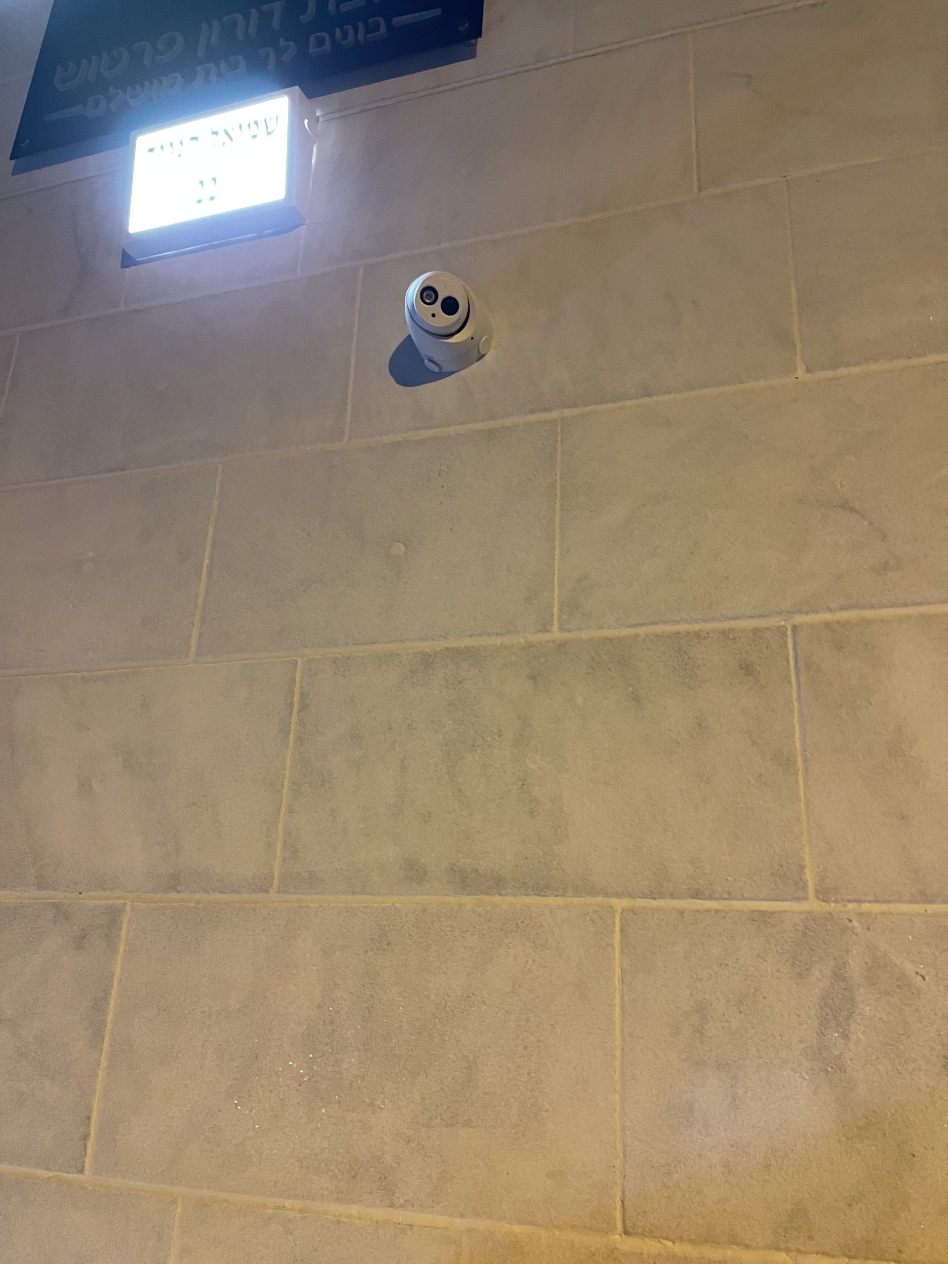 מצלמה תלויה מתקרת בניין.