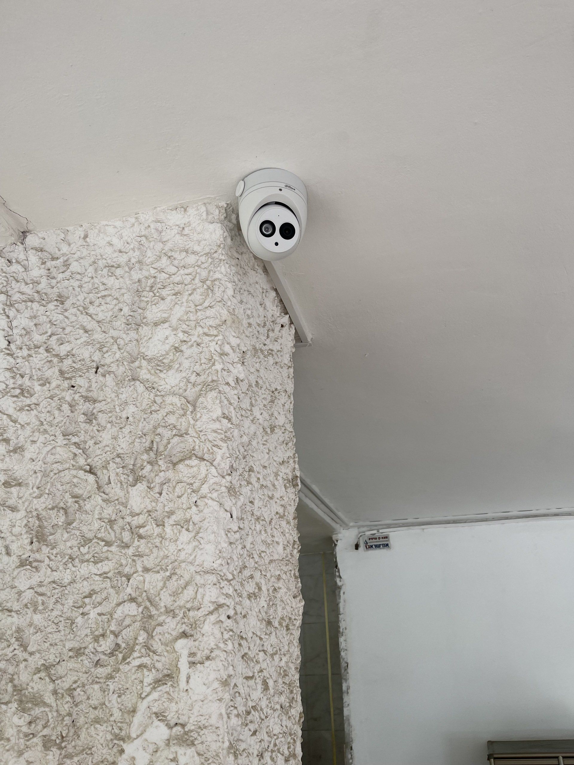 מצלמת אבטחה מותקנת על תקרת הבניין.