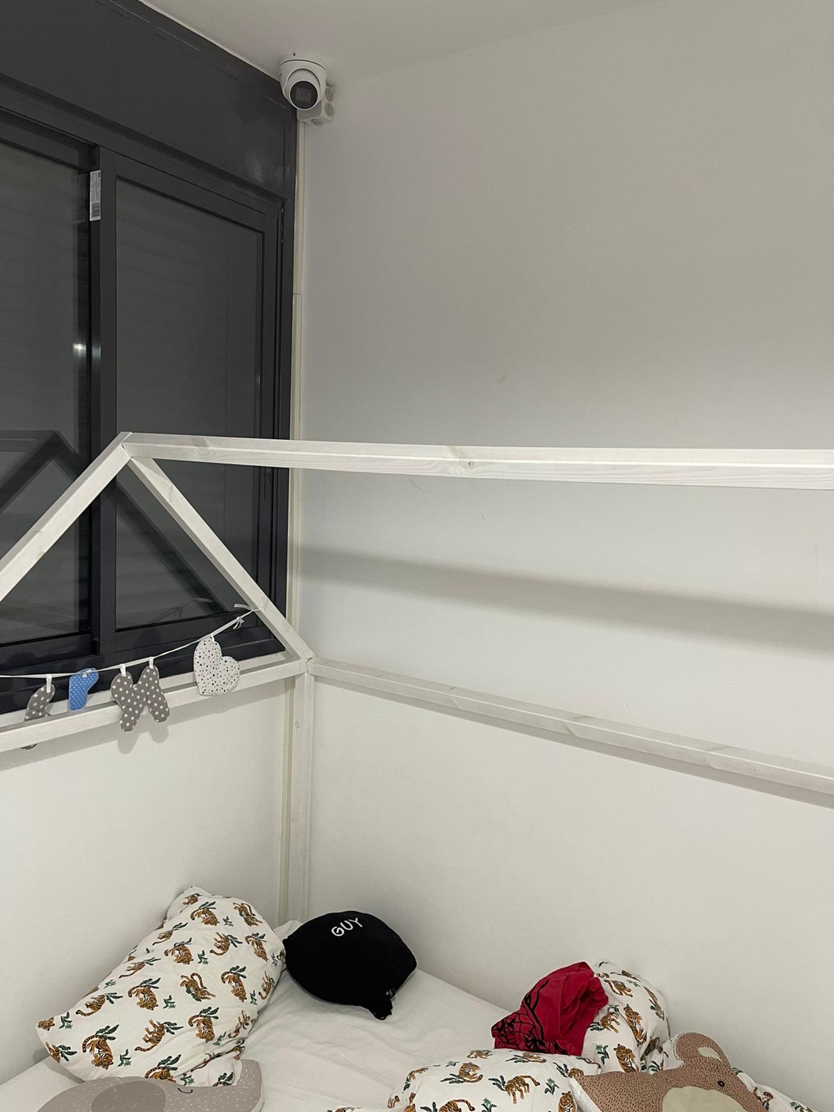 מיטה עם חופה וחלון בחדר שינה.