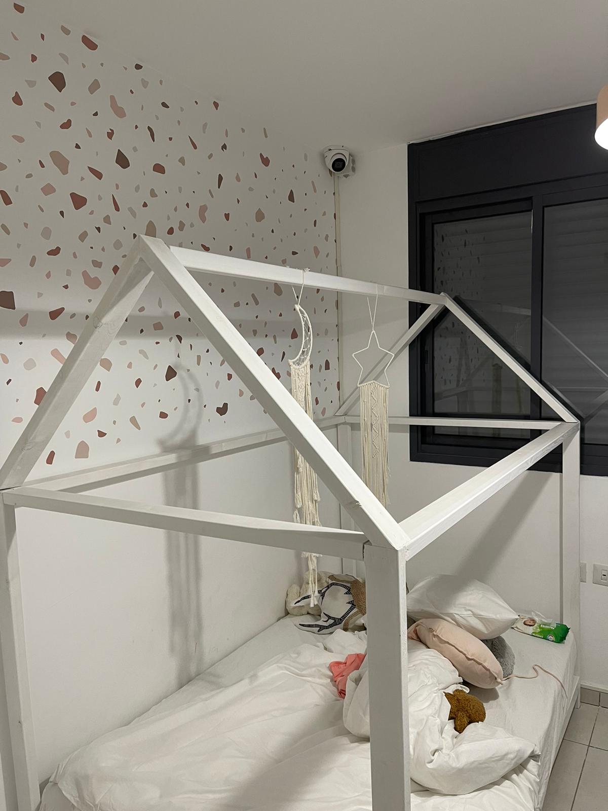 חדר שינה עם מיטה בצורת בית.