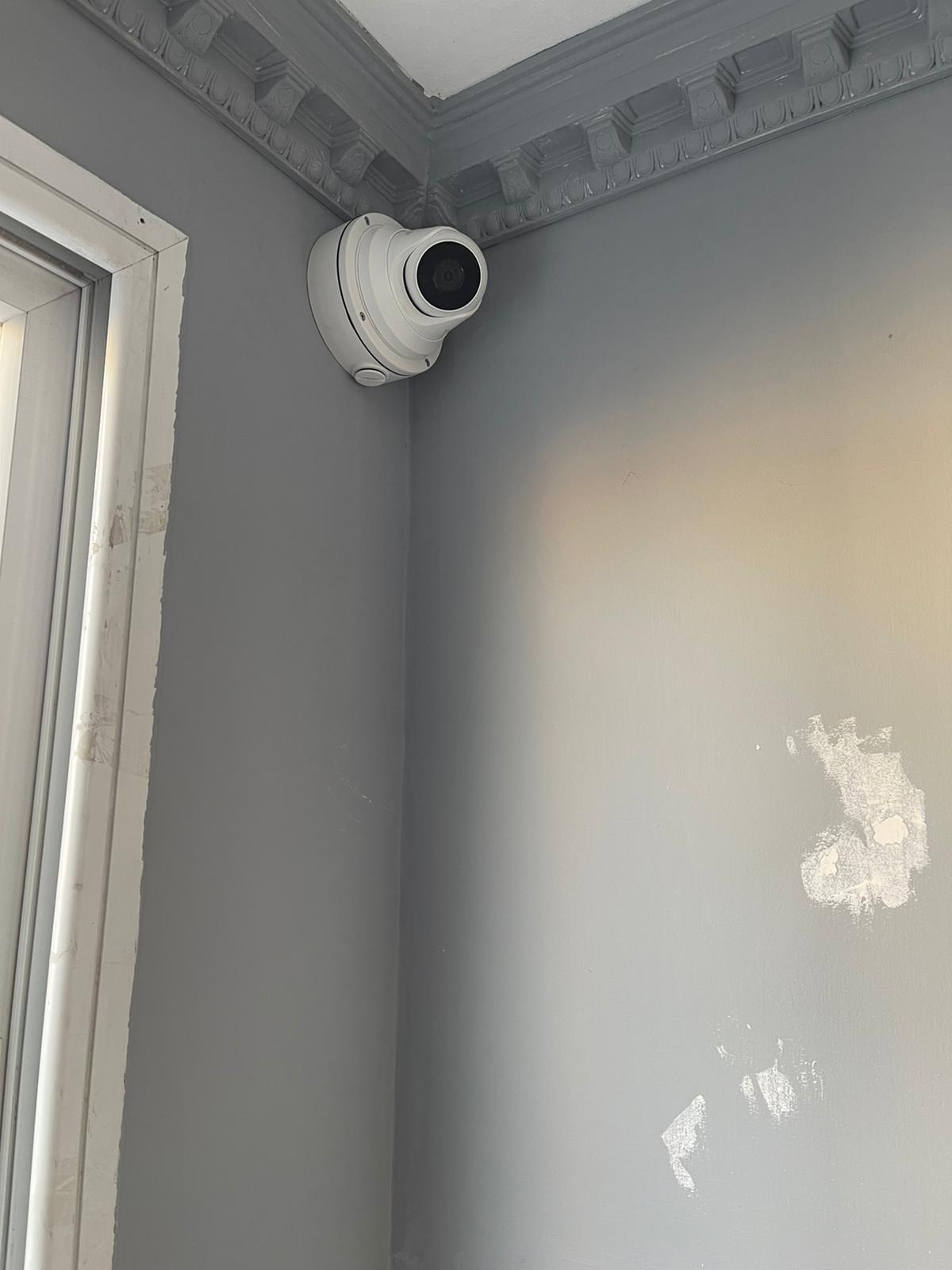 מצלמה מותקנת בפינת קיר ליד חלון.