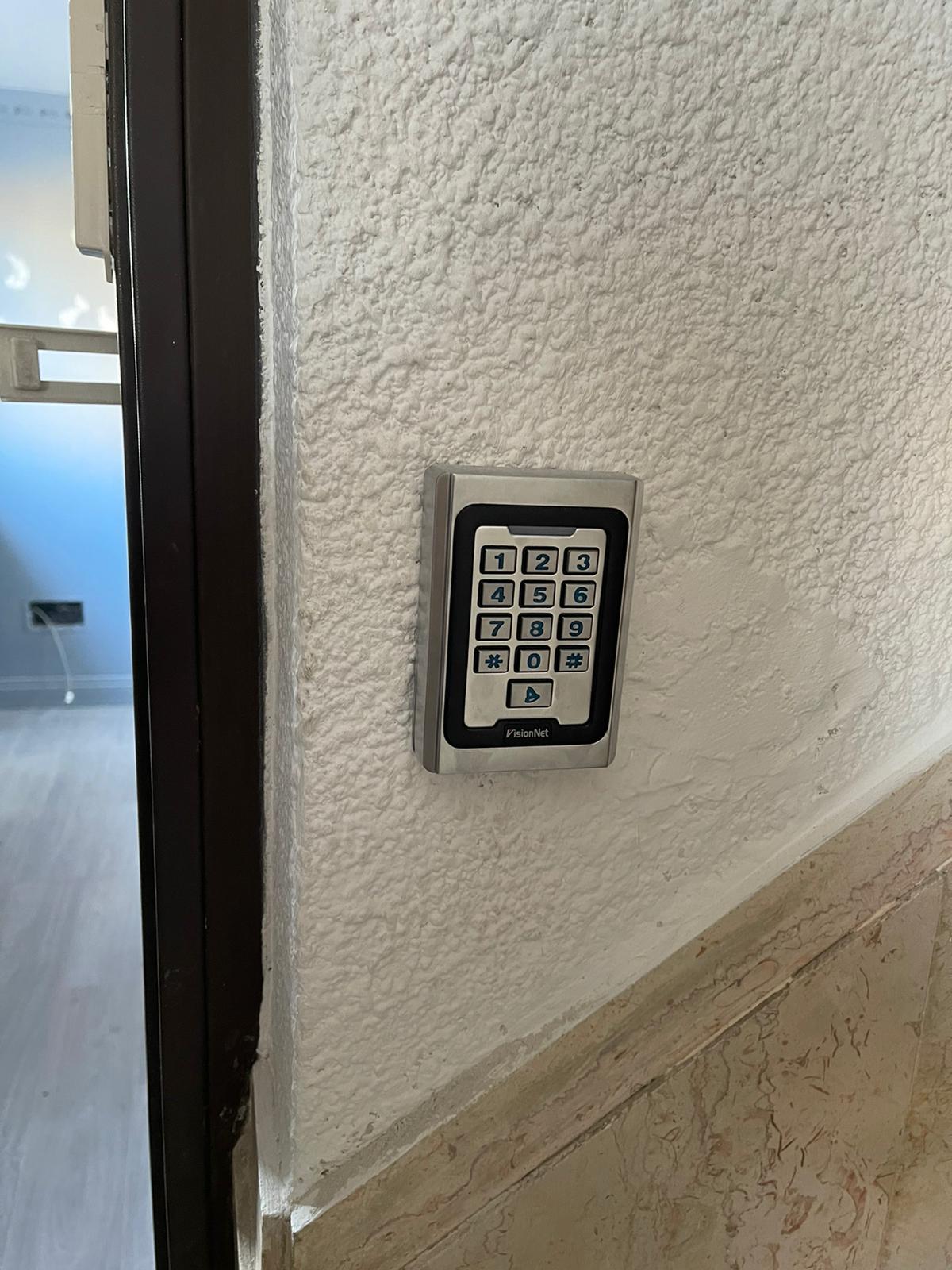 תקריב של לוח מקשים על קיר ליד דלת.