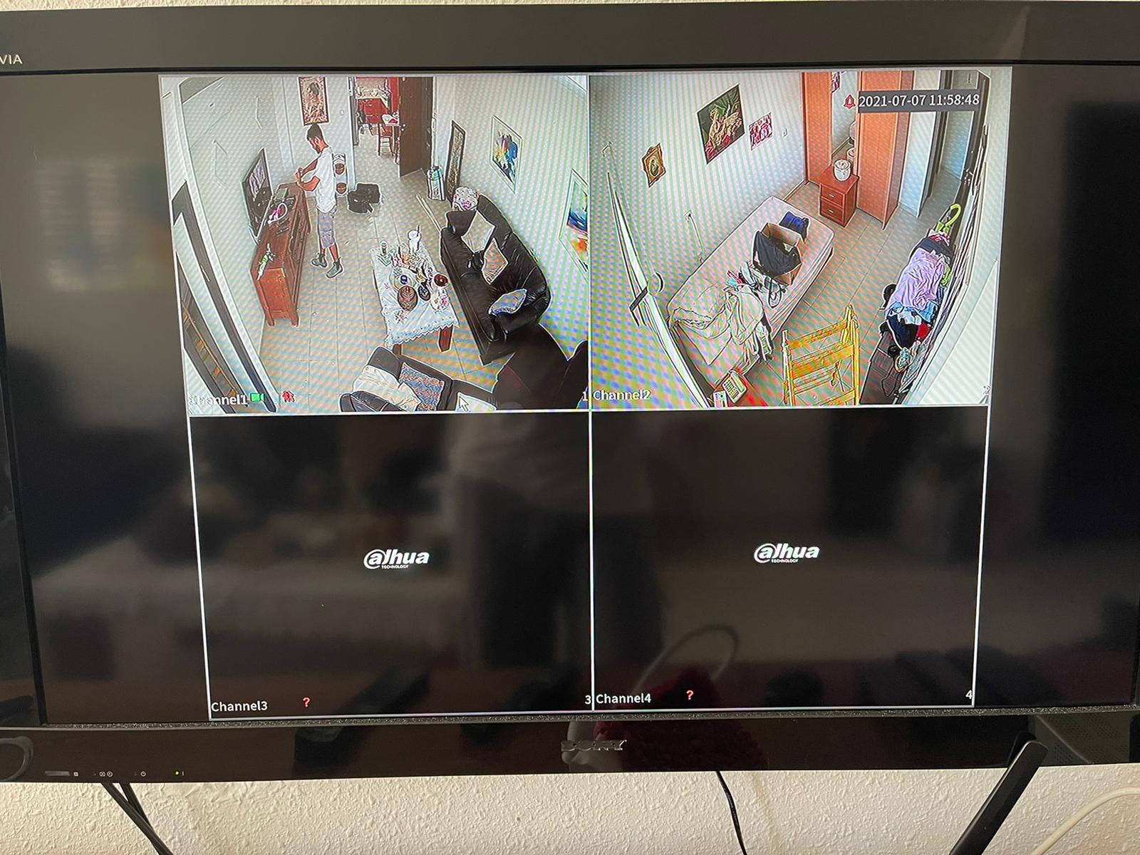 מסך טלוויזיה מראה חדר שינה עם שתי מצלמות עליו.