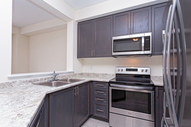 A kitchen with stainless steel appliances and granite counter tops.