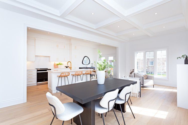 A dining room with a black table and white chairs