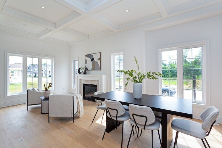 A living room with a dining table and chairs and a fireplace.