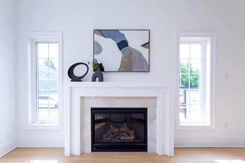 A living room with a fireplace and a painting on the wall.