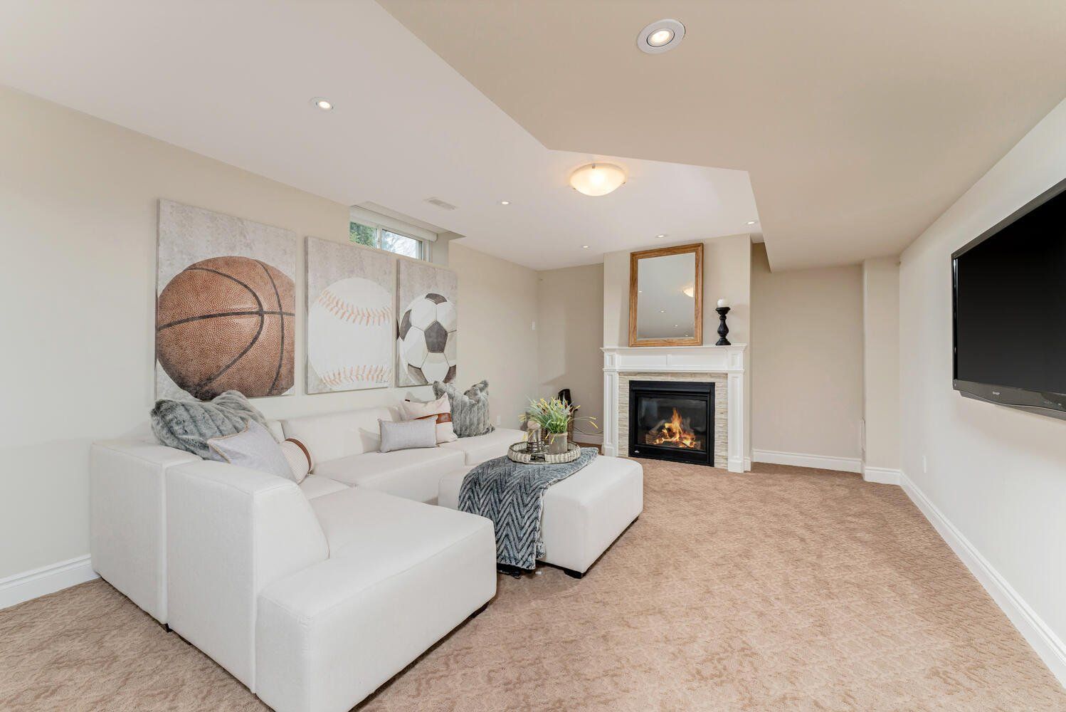 A living room with a couch , fireplace and television.