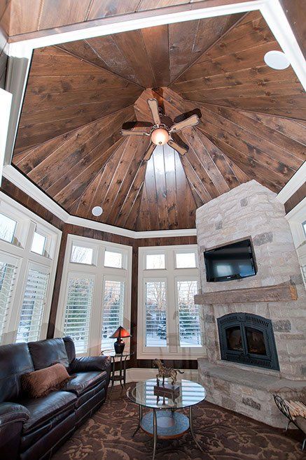 A living room with a ceiling fan and a fireplace.