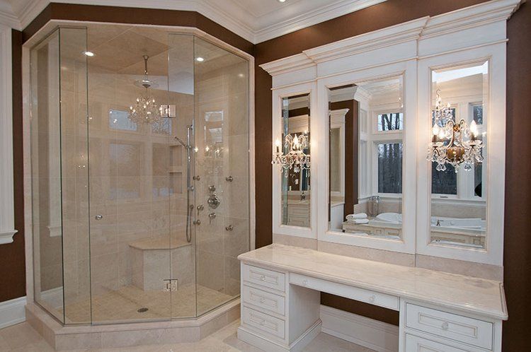 A bathroom with a walk in shower and a vanity.
