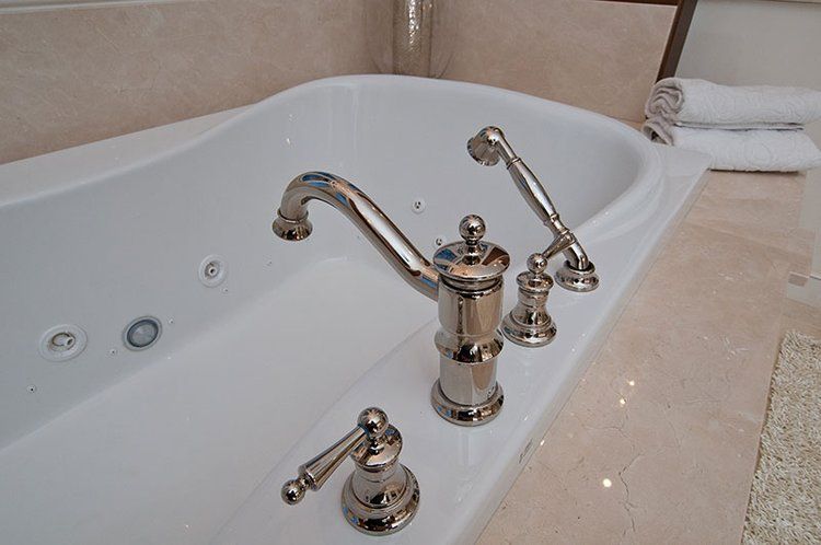 A bathtub with chrome faucets in a bathroom