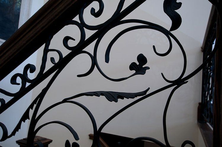 A close up of a wrought iron railing on a staircase