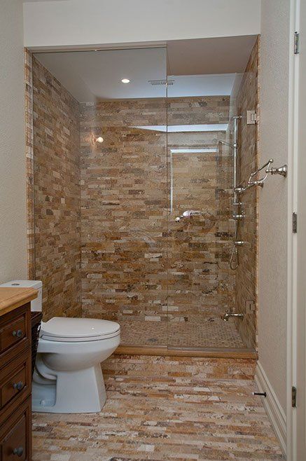 A bathroom with a toilet and a walk in shower.