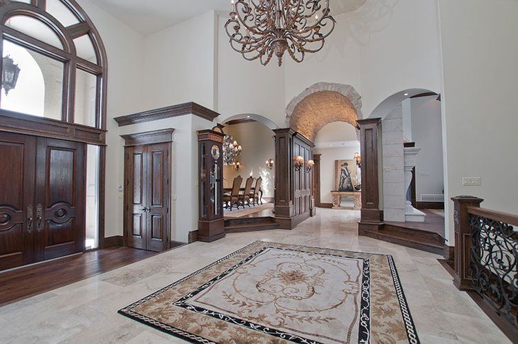 A large hallway with a rug on the floor and a chandelier hanging from the ceiling