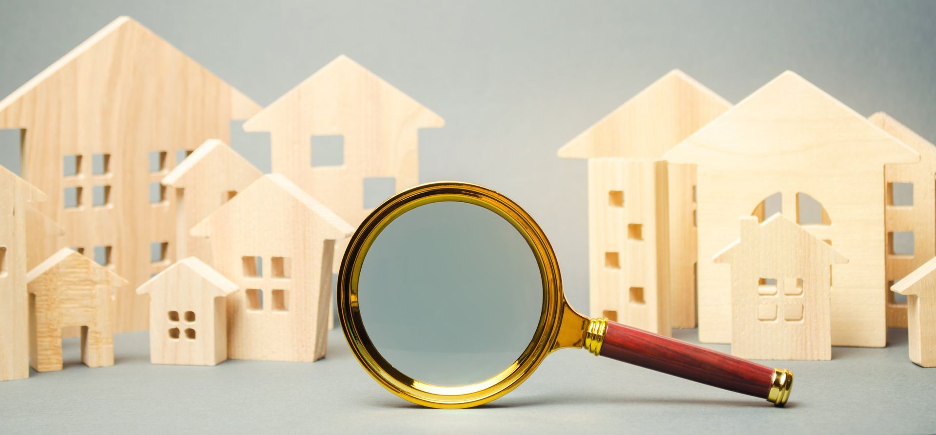 A magnifying glass is sitting in front of a row of wooden houses.