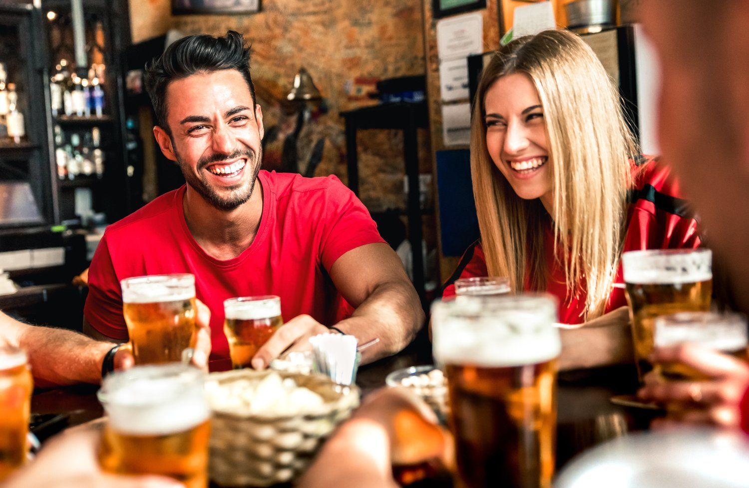 A group of people are sitting at a table drinking beer.