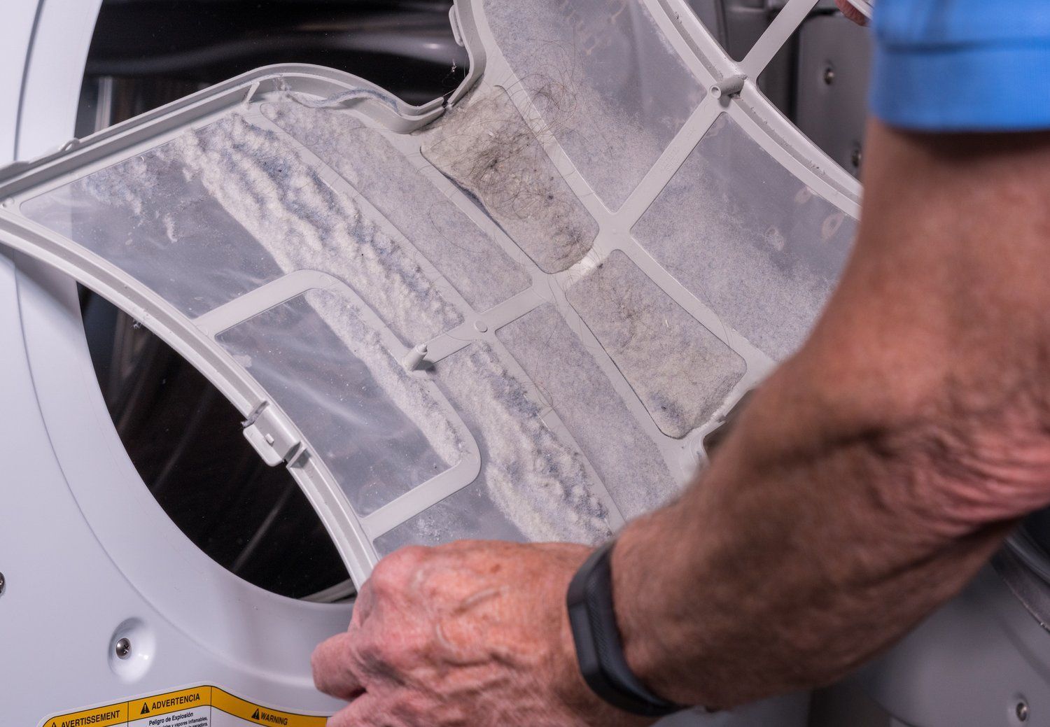 A person is cleaning a dirty dryer filter.