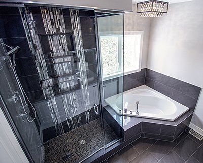 A bathroom with a tub , shower and walk in shower.