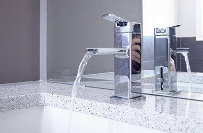 A bathroom sink with a faucet and a mirror.