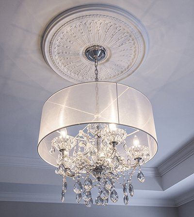 A chandelier with a white shade is hanging from the ceiling.