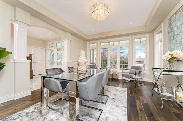 A dining room with a glass table and chairs and a chandelier.