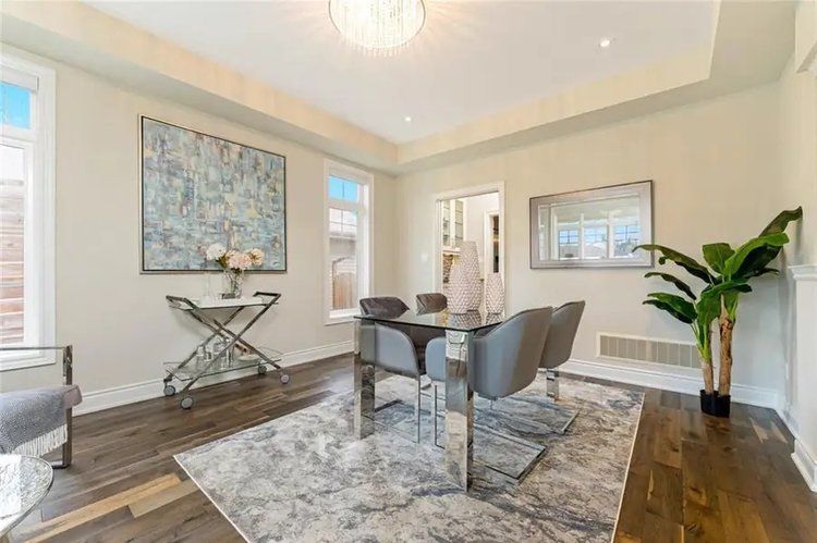 A dining room with a table and chairs and a rug.