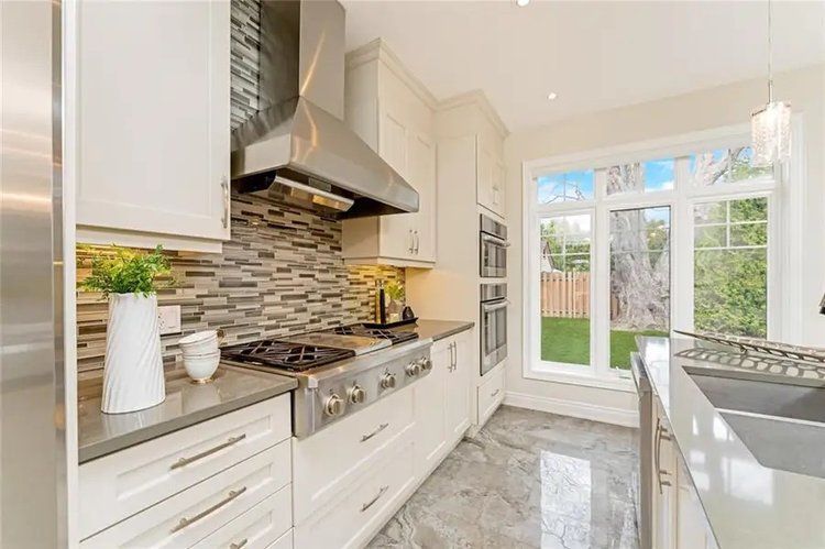 A kitchen with white cabinets and stainless steel appliances.