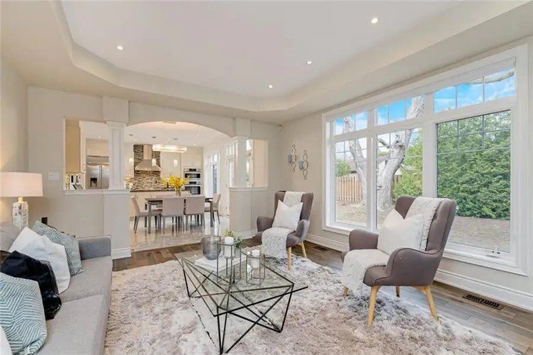 A living room with a couch , chairs , and a coffee table.