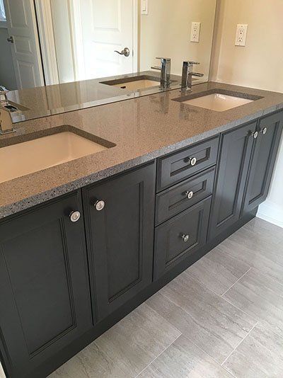 A bathroom vanity with two sinks and a large mirror.