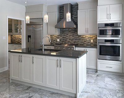A kitchen with white cabinets and stainless steel appliances.