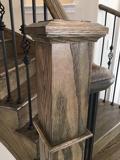 A close up of a wooden post on a staircase.