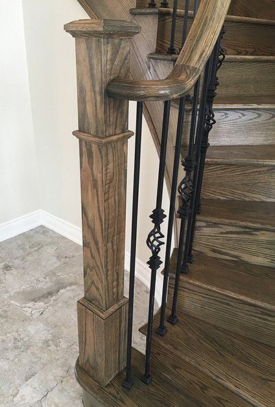 A close up of a wooden staircase with a metal railing.
