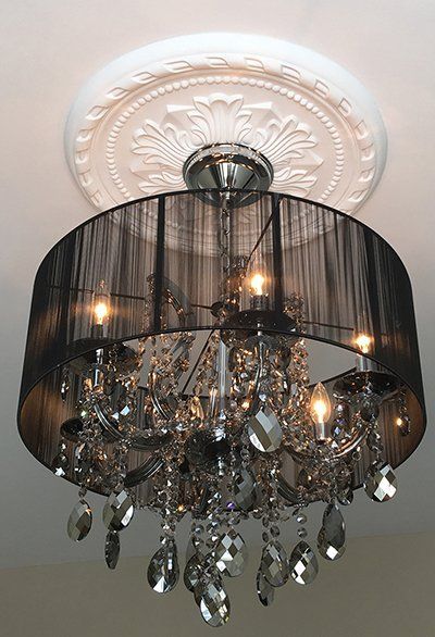 A chandelier with a black shade is hanging from the ceiling.