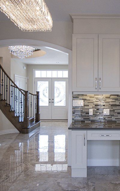 A kitchen with a staircase and a chandelier hanging from the ceiling.