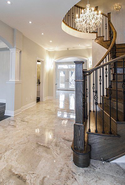 A hallway with a spiral staircase and a chandelier.