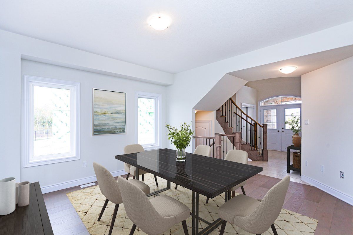 A dining room with a table and chairs and a staircase.