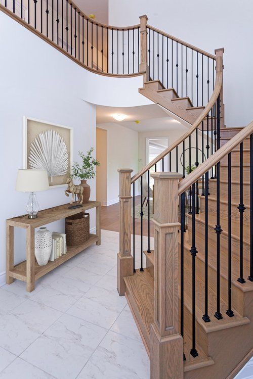 A wooden staircase with a black railing in a house