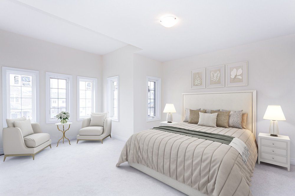 A bedroom with a bed , chairs , lamps and windows.