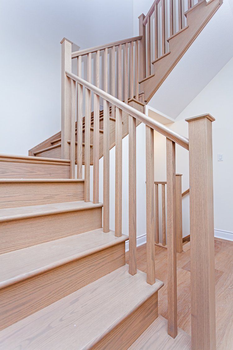 A wooden staircase with a wooden railing in a house.