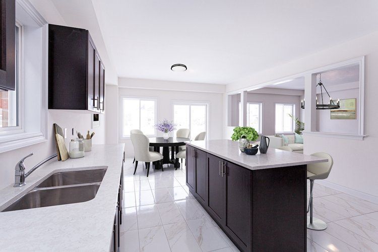 A kitchen with two sinks and a dining room in the background.