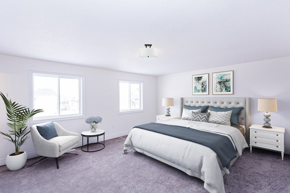 A bedroom with a bed , chair , nightstand , table and purple carpet.