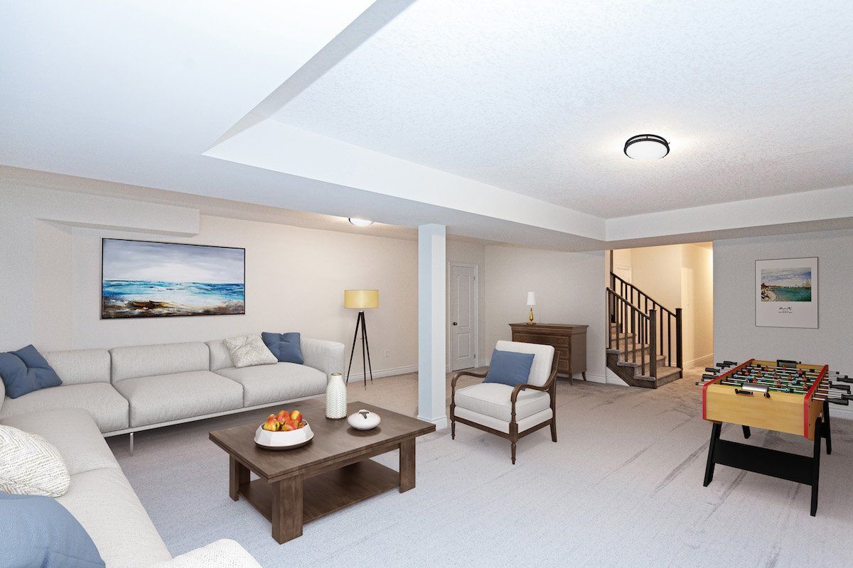 A living room with a couch , chair , coffee table and foosball table.