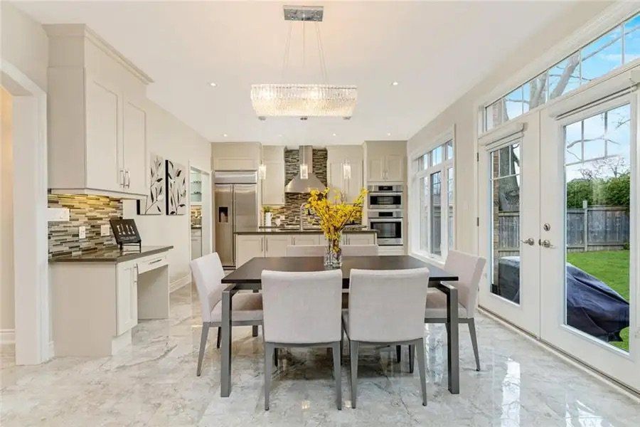 A dining room with a table and chairs and a kitchen