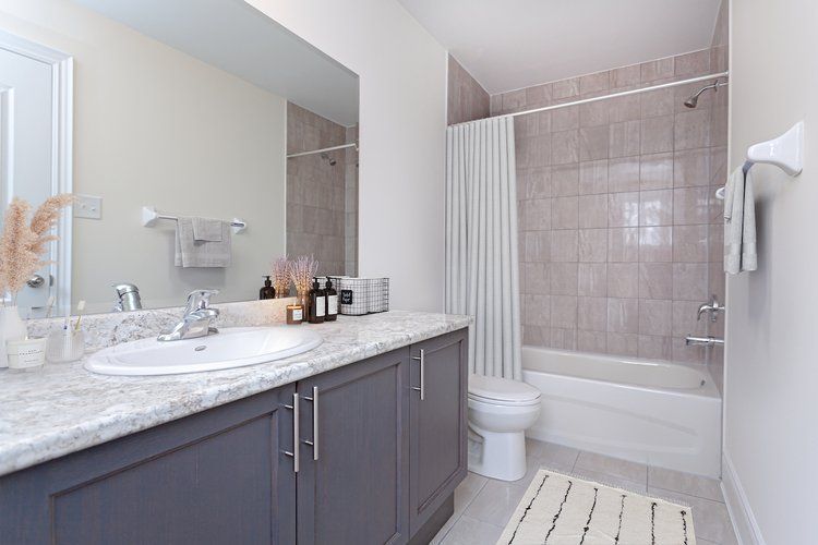 A bathroom with a sink , toilet , bathtub and mirror.