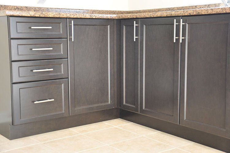 A kitchen with black cabinets and granite counter tops