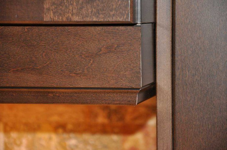 A close up of a wooden cabinet with drawers.